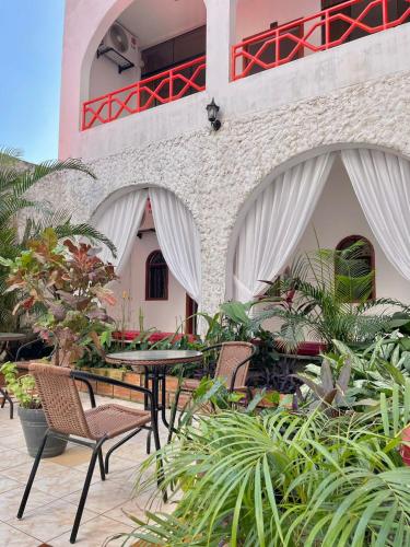 eine Außenterrasse mit Tischen, Stühlen und Pflanzen in der Unterkunft Hotel Firenze in Tarapoto