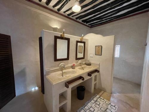 拉穆的住宿－Umma House，一间带水槽和两面镜子的浴室