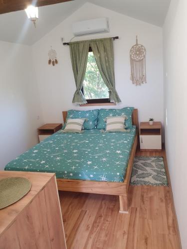 a small bedroom with a bed with a window at Bungalov Lenka in Temerin