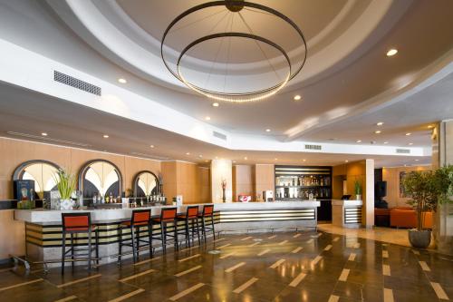 a bar in a hotel lobby with a chandelier at Hotel Bel Azur Thalasso & Bungalows in Hammamet