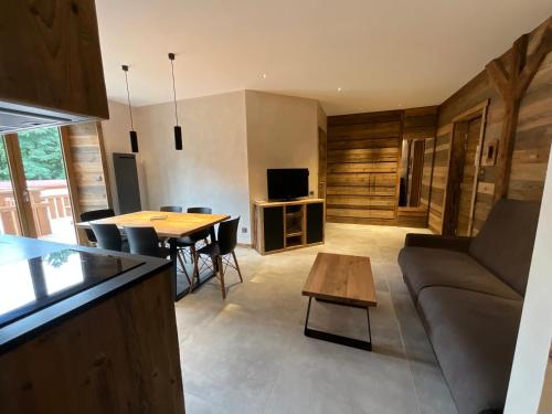 a living room with a couch and a table at Gite Roche Des Ducs avec Piscine toute l'année, Spa, Sauna, Hammam in Rochesson