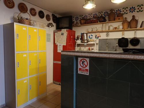 a kitchen with yellow cabinets and a red refrigerator at 10 Coins Hostel & tours in Sofia