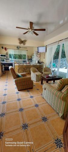 a living room with couches and a ceiling fan at YETHAN HOUSE in Uvita