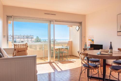 - un salon avec une table et une vue sur l'océan dans l'établissement le bruit des vagues sur gîte echarou, à Port-la-Nouvelle