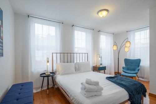 a bedroom with a bed and two blue chairs at The Stairway Suites - Convention Center in Philadelphia