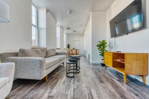 a living room with a couch and a tv at The Stairway Suites - Convention Center in Philadelphia