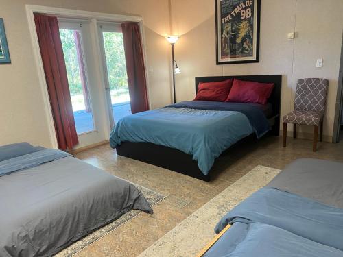 a bedroom with two beds and a window at The Big Red Barn in Whitehorse