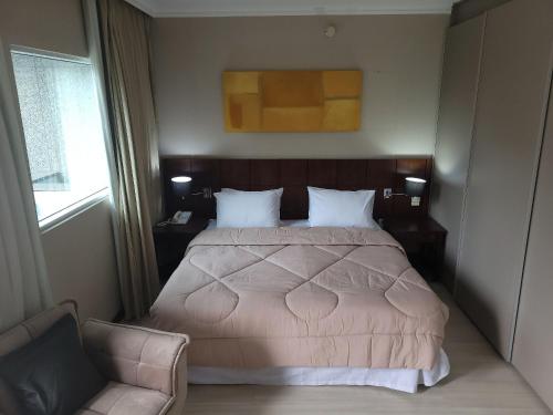 a bedroom with a large bed and a couch at Flat Super Luxo Verbo Divino in Sao Paulo