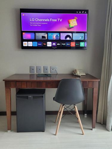 a desk with a chair and a television on a wall at Flat Super Luxo Verbo Divino in Sao Paulo
