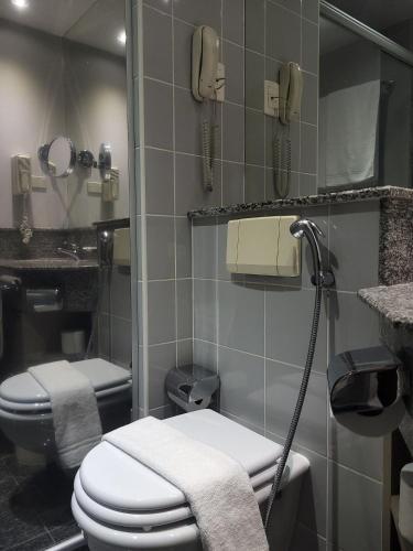 a bathroom with a toilet and a phone at Flat Super Luxo Verbo Divino in Sao Paulo