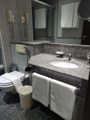a bathroom with a sink and a toilet with towels at Flat Super Luxo Verbo Divino in Sao Paulo