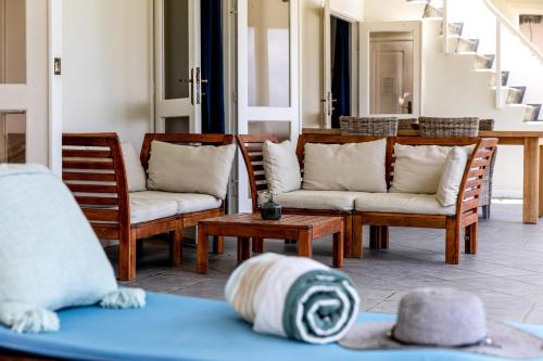 a porch with chairs and a table with a hat at Oceanfront - Villa Port of Call - in Kralendijk