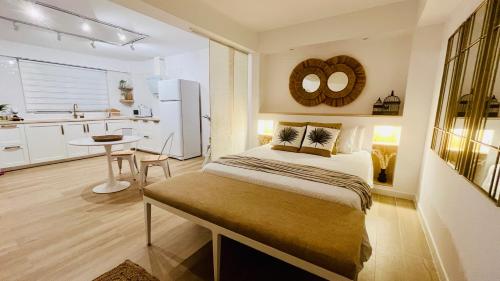 ein Schlafzimmer mit einem Bett und eine Küche mit einem Tisch in der Unterkunft EL PISITO SAND, a 700 metros del casco antiguo in Marbella
