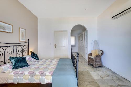 a bedroom with a bed and a chair at Oceanfront - Villa Port of Call - in Kralendijk