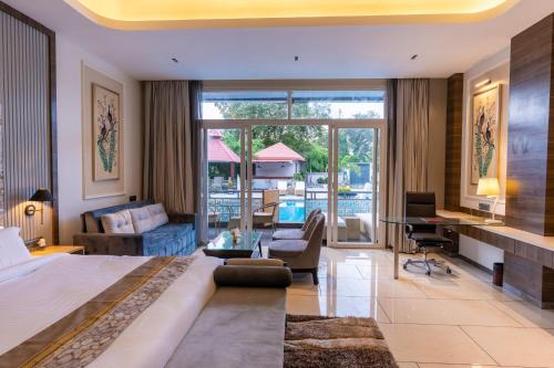 Una habitación de hotel con una cama grande y una sala de estar. en Mountain Creek Villa Udaipur, en Udaipur