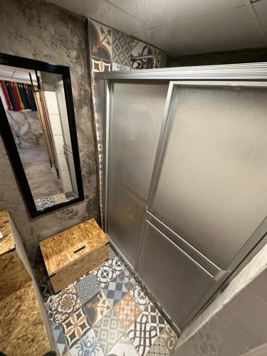 a bathroom with a metal door and a mirror at CASA CRISTOBAL Siete Cuartones in Cusco