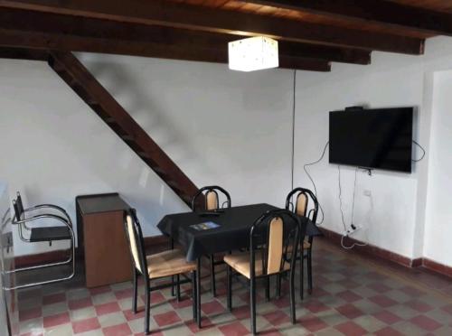 a dining room with a table and chairs and a flat screen tv at Loft centrico in Villa Cubas