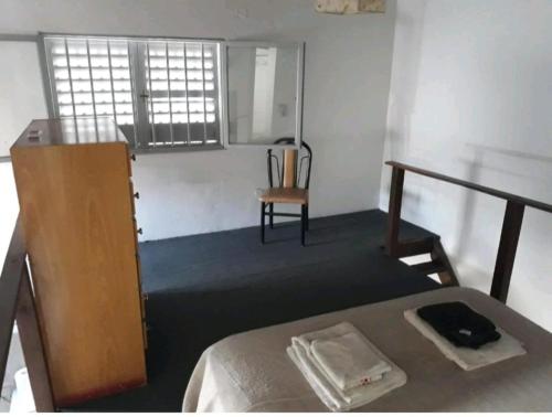 a bedroom with a bed and a chair and a window at Loft centrico in Villa Cubas