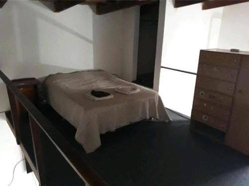 a small bedroom with a bed and a dresser at Loft centrico in Villa Cubas