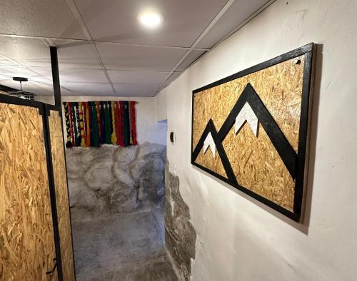 a room with a painting on the wall and a door at CASA CRISTOBAL Siete Cuartones in Cusco