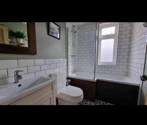 y baño con bañera, aseo y lavamanos. en Lovely double bedroom house 1 en Buckinghamshire