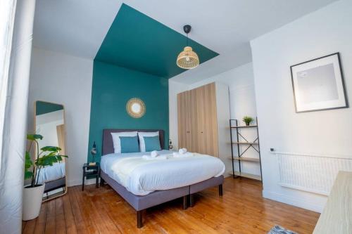 a bedroom with a large bed with a blue wall at Wellness Bubble - Cathédrale - Hypercentre in Reims