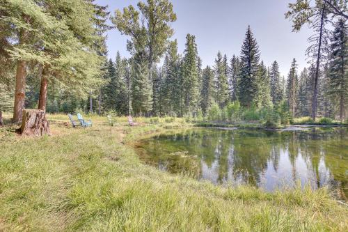 a park bench next to a pond in a forest at Eureka Vacation Rental Steps to Creek and Fishing! in Eureka