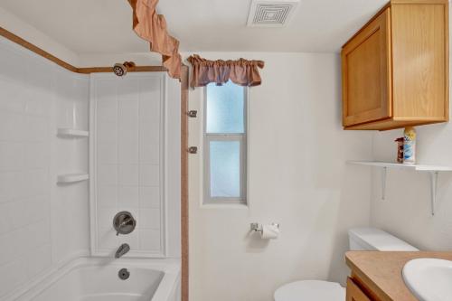 a bathroom with a shower and a toilet and a sink at Peach Cabin in Fredericksburg