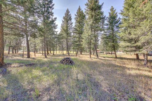 a pile of logs in a field with trees at Eureka Vacation Rental Steps to Creek and Fishing! in Eureka