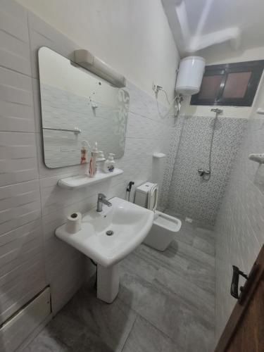 ein Badezimmer mit Waschbecken, Spiegel und Toilette in der Unterkunft Superbe studio surplombant la plage de yoff A5 in Dakar
