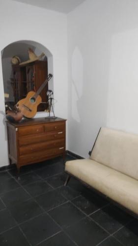 a room with a couch and a dresser with a guitar at HOSTAL DE PARQUE in El Carmen