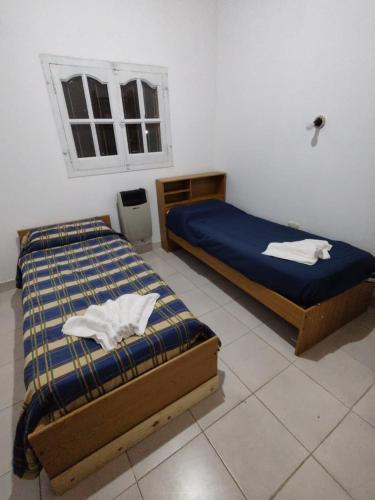 sypialnia z 2 łóżkami i oknem w obiekcie HOSTAL DE PARQUE w mieście El Carmen