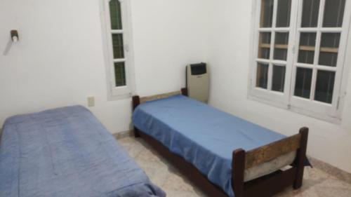 sypialnia z 2 łóżkami i 2 oknami w obiekcie HOSTAL DE PARQUE w mieście El Carmen