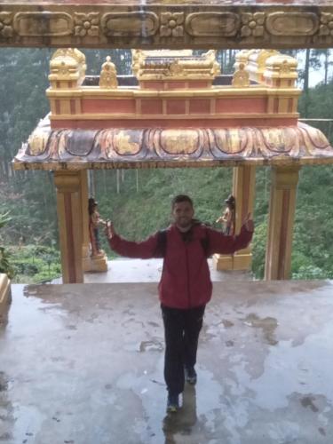 a man walking in front of a temple at Trinish homestay in Hatton