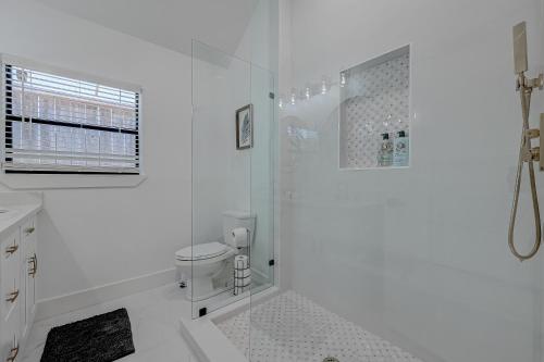 a white bathroom with a shower and a toilet at Stylish, 2 Bedroom in Houston-Bellaire in Houston