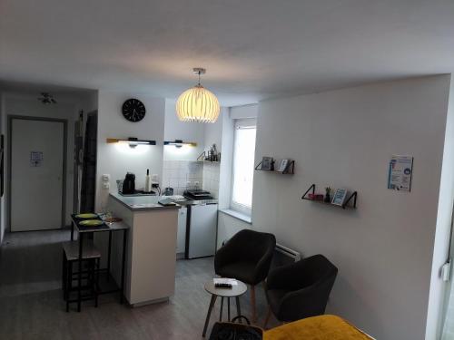 - une cuisine avec un comptoir et des chaises dans la chambre dans l'établissement VITTEL LOC'S - Le 6, calme avec terrasse privative, à Vittel