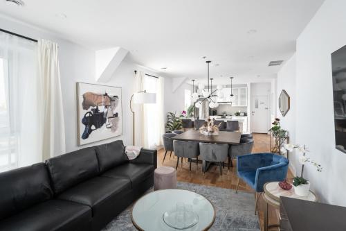 a living room with a black couch and a dining room at Les Lofts du Mont Royal in Montréal