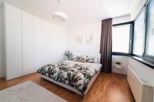 a bedroom with a bed with plants on it at Prague Marina River View Apartment Close To City Centre FREE PARKING in Prague