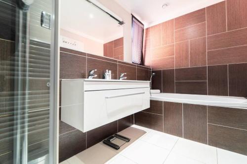 a bathroom with a white sink and a shower at Prague Marina River View Apartment Close To City Centre FREE PARKING in Prague
