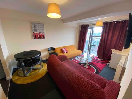 un soggiorno con divano rosso e tavolo di Igloo ViewPoint II City Centre Retreat + Parking a Sheffield