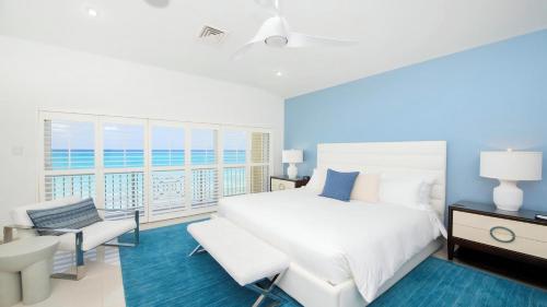 a bedroom with a white bed and a balcony at Laguna Del Mar in George Town