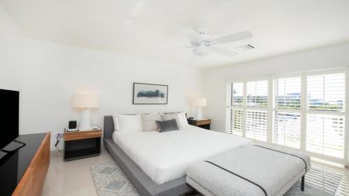a white bedroom with a bed and a window at Laguna Del Mar in George Town