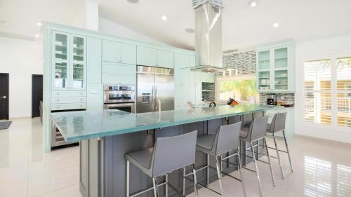 a kitchen with a blue counter and stools at Laguna Del Mar in George Town