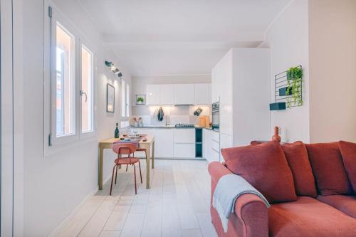 un soggiorno con un divano rosso e una cucina di Red Ferrari House - City center a Modena