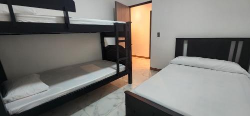 two bunk beds in a room with a bed at Apartamento Acogedor y Moderno in Santa Rosa de Cabal
