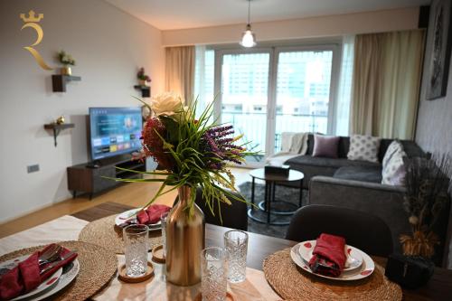 a living room with a table with a vase of flowers at Luna Breeze - Elegant 2BR Apartment with Beach Access, Near Al Raha Beach in Abu Dhabi