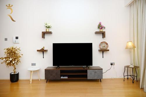 a living room with a flat screen tv on a wall at Luna Breeze - Elegant 2BR Apartment with Beach Access, Near Al Raha Beach in Abu Dhabi