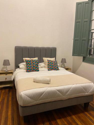 a bedroom with a large bed with two tables and two lamps at Casa Marina Huérfanos in Santiago