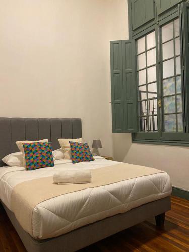 a large bed with two pillows on it in a bedroom at Casa Marina Huérfanos in Santiago