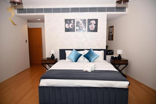 a bedroom with a large bed with blue pillows at Your 2BR Luna Retreat with Beach Access in Al Rahba in Abu Dhabi
